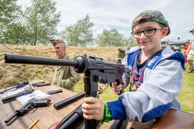 Jonas Hichley, aged eight, tries his hand at some of the war-time weaponry on display at the event.
