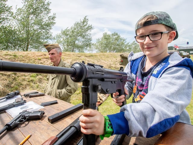 Jonas Hichley, aged eight, tries his hand at some of the war-time weaponry on display at the event.