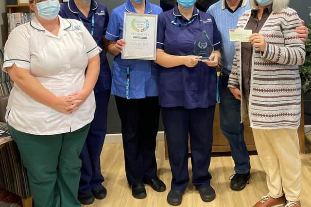 Maureen Davies and her husband Peter (right) presenting a cheque for £1,000 to the Scarbrough Ward.
