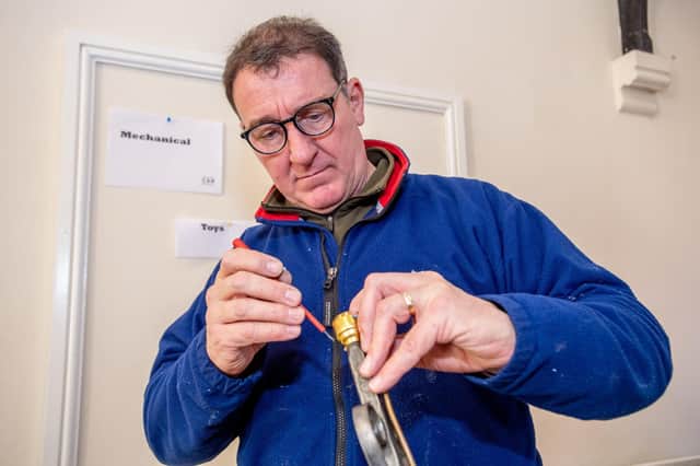 Steve Maidment carrying out electrical and mechanical repairs at the cafe event. Photo: John Aron