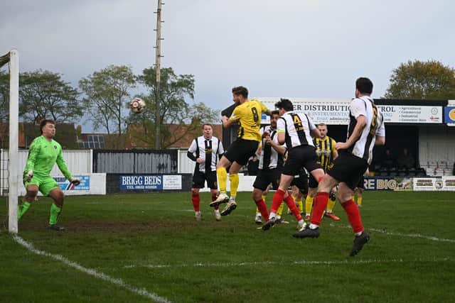 Stephen McCarron (no.4) heads home Brigg's fifth goal on Saturday. Photo: Anna Backstrom/Brigg Town FC.