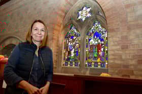 Church volunteer, Helen Poppleton of LIttle Cawthorpe, with one of the windows that was vandalised during Covid, and replaced in June 2024. Photo: David Dawson