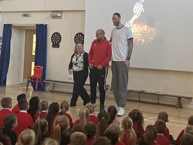 Paul in the whole school assembly, competing with teacher Rowan Evans for the tallest man at Staniland Academy record.