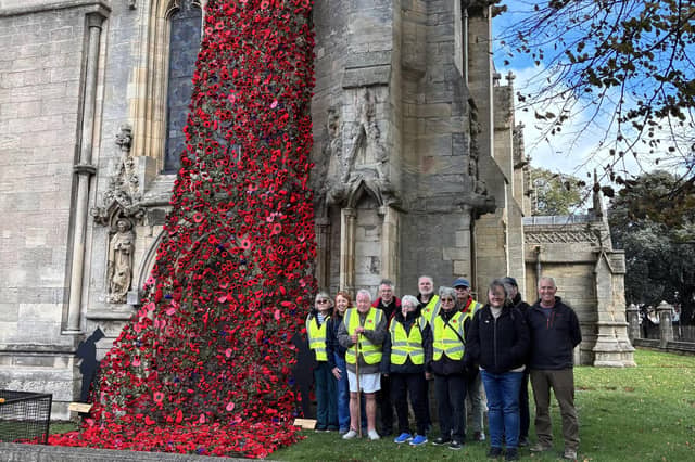 Volunteers proudly stand beside the installed poppy cascade at St Denys' Church. Photo: Julie Butler