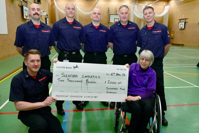 Firefighters L-R Colin Calam, George Benson, Stu Hill, John Wheat, Stu Annible and Bob Machin presenting a cheque to Thelma Smith. Photo: David Dawson