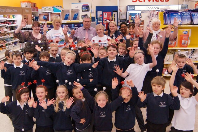 Children from the Falcons class at Market Rasen Primary School with staff at the town’s Tesco store, performing the Cha Cha Slide in aid of school pool roof funds.