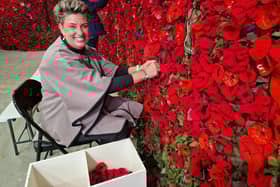 Volunteer Lynne Priestly tying on poppies.