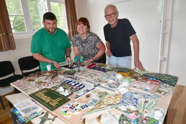 Assembling the community mosaic. L-R Nils Wilkinson, artist/designer Rachael Audrey Clark-Harris and Robert Clark. Photo: David Dawson