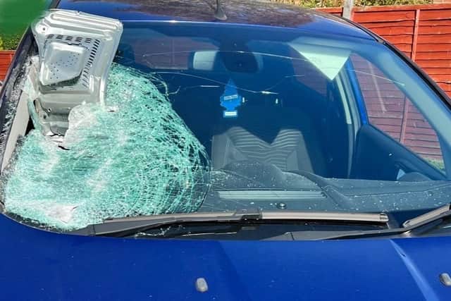 The microwave was lodged into the glass, causing the windscreen to shatter and glass to spray inside the car