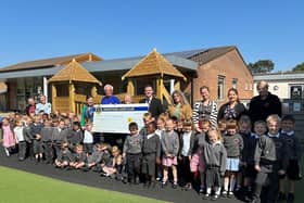 The Grantham Lions hand over the £1,000 cheque to the headteacher, staff, and pupils