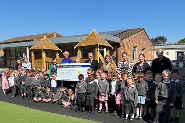 The Grantham Lions hand over the £1,000 cheque to the headteacher, staff, and pupils