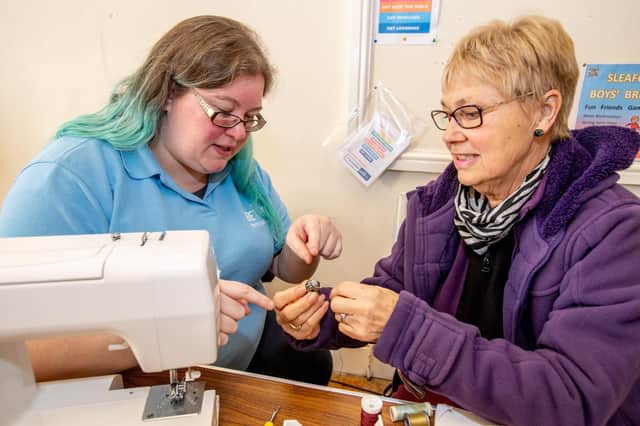Stephanie Pleasance (left) offering clothing and textiles repairs with Pauline Dobson learning basic sowing machine skills. Photo: John Aron