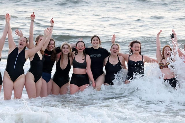The girls look jubilant as they pose for a photo in the water.