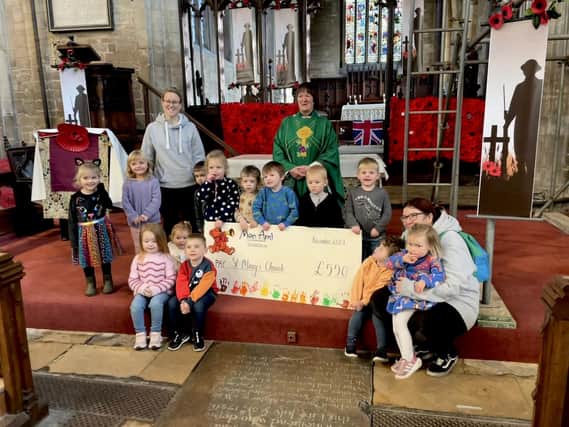 Mon Ami Children's Nursery, in Swineshead, donating funds from its sponsored scarecrow walk to the village's St Mary's Church.
