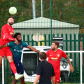 Tom Ward heads clear during the game with Newark & Sherwood. Photo: Steve W Davies Photography.