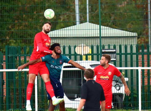 Tom Ward heads clear during the game with Newark & Sherwood. Photo: Steve W Davies Photography.
