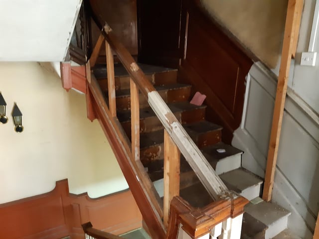 This staircase leads to the attic, but previously it was hidden behind a cupboard. Behind the cupboard, Shane found a staircase full of hat and suit boxes. Upstairs, finds included an old till and financial records dating back decades and evidence of people living there (such as indentations on the floor from bed legs and blisters on the wall from lamps).