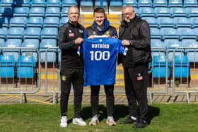 Lewis Butroid is presented with a commemorative shirt for his 100 appearances from boss Russ Wilcox and assistant manager Kevin Pressman.