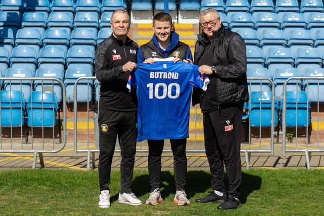 Lewis Butroid is presented with a commemorative shirt for his 100 appearances from boss Russ Wilcox and assistant manager Kevin Pressman.
