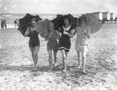 Four bathing belles shading themselves with parasols on the beach at Skegness in 1926.