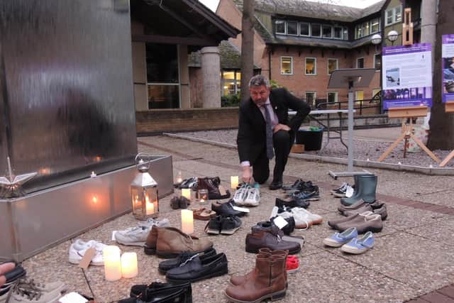 Council Leader Coun Richard Wright passes on his old trusty trainers at the memorial event.
