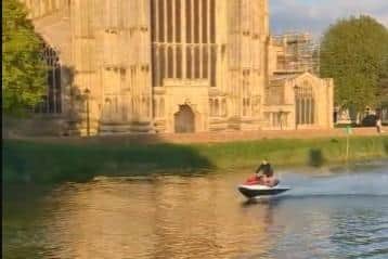 A still from the video showing jet ski riders on the River Witham, with the Stump in the background
