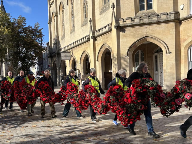 An army of volunteers march across the Market Place to install the poppy cascade.