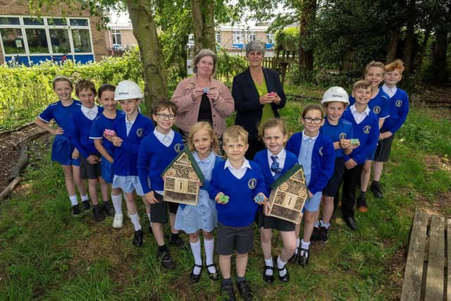 Tracey Kirlew, a higher-level teaching assistant and Green Team leader at Pinchbeck East CofE Primary Academy, and Teeny Vayro, Head of School, are pictured with the school's Green Team holding donated bee hotels and ‘bee bombs’ provided by Bellway.