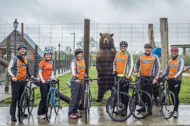 Pictured at Wolds Wildlife Park before his cycling challenge, Simon Eyley (third right) with colleagues George Varvitsiotis, Olivia Stephenson, Sam Stevens, Keith Gothorp, and John Gothorp and Maxi the European brown bear.