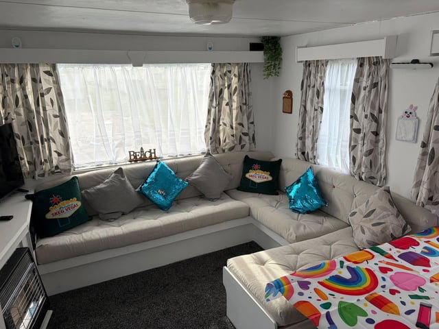 The living area with re-upholstered sofas featuring buttons with character faces on.