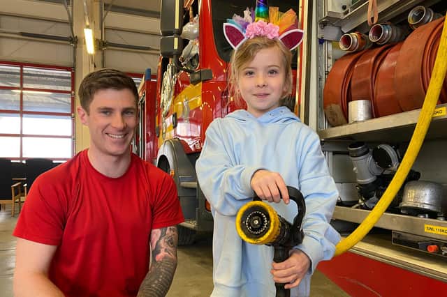 Florence Selby tries a water hose on the fire engine.