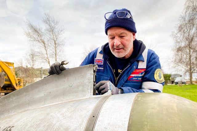 Volunteer Josh Mortimer gets to work on replacing part of the Lightning's Radome.