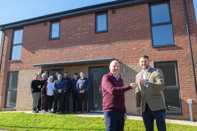 Simon Dillon (front left), Development Manager at Amplius, receives the keys from Adam Mayer, Managing Director of D Brown Building Contractors, watched by colleagues from the two organisations.