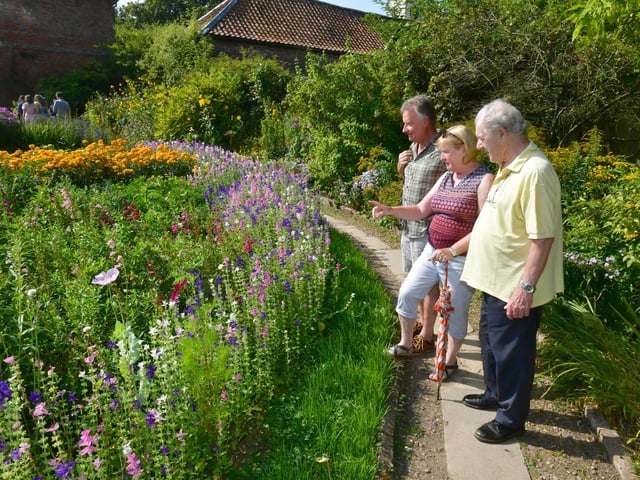 Everything in the gardens is lovely with (from left) Nigel Bradley, Susan Wooward and John Randall.