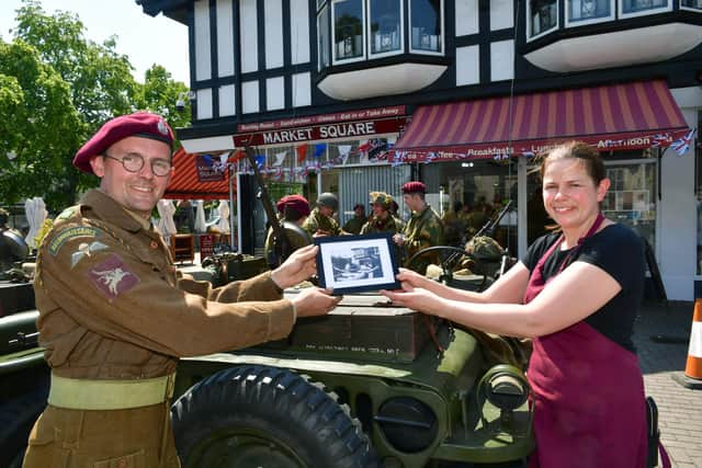 Re-enactment group co-ordinator Matthew Moore presenting an old photo of the squadron when it was being kitted out in Sleaford market place to Market Place Cafe manager, Sarah Cook.