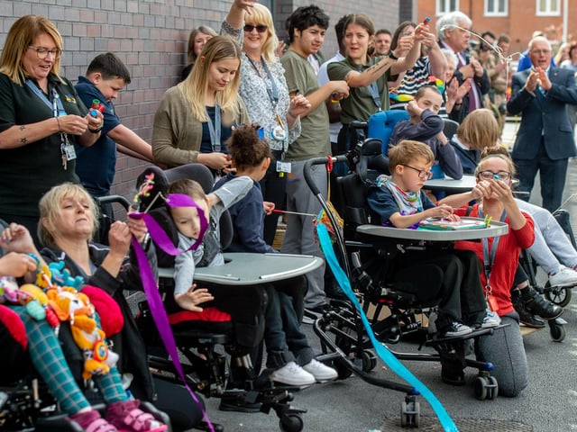 Parents, pupils and staff let off party poppers to celebrate the opening of their new school.
