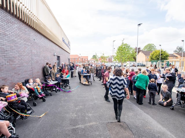 School staff, pupils and supporters gather outside the new school building as it is officially opened.