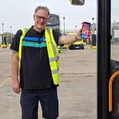 Local bus driver James Blaydon demonstrates how the company would like its passengers waiting at bus stops to use their mobile phones to be seen by drivers during darkness hours.