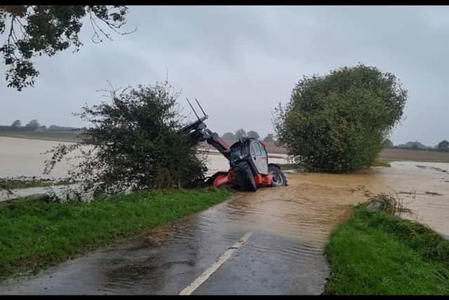 A tractor submerged in water in a field at Ashby by Partney.