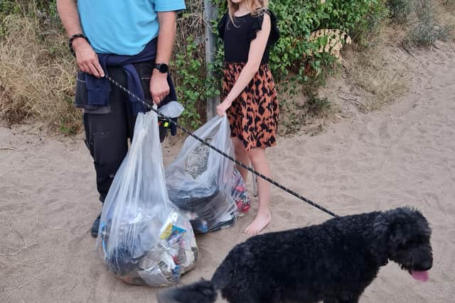 Sofia picking litter with her dad and dog.