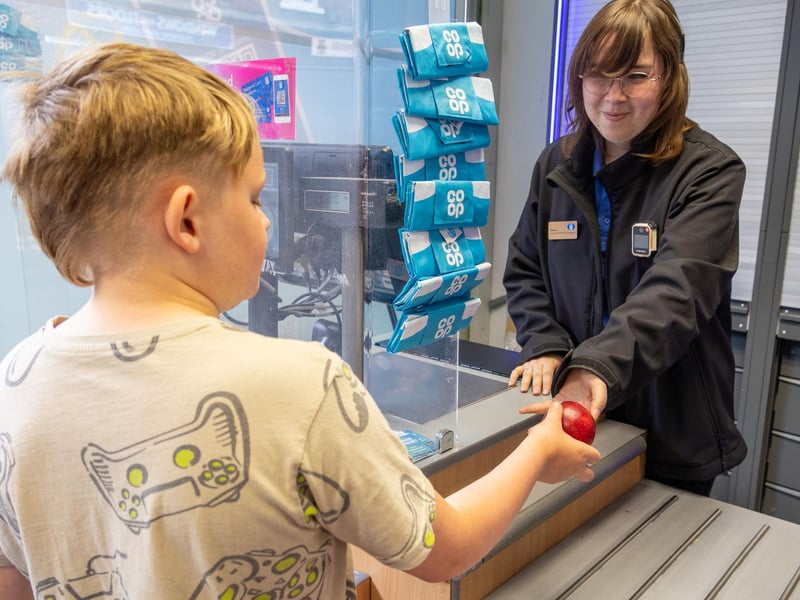 Child getting free fruit at till