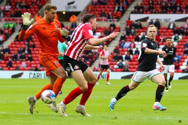 Ross Stewart goes down under a challenge from Lincoln keeper Baxter but no penalty is given.