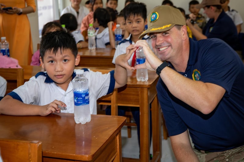 Royal Navy Capt. Joseph Dransfield, Pacific Partnership 2023 deputy mission commander, poses for a photo with a Hoa Dinh Tay Primary School student before a ribbon cutting ceremony for three new classrooms constructed during Pacific Partnership 2023.