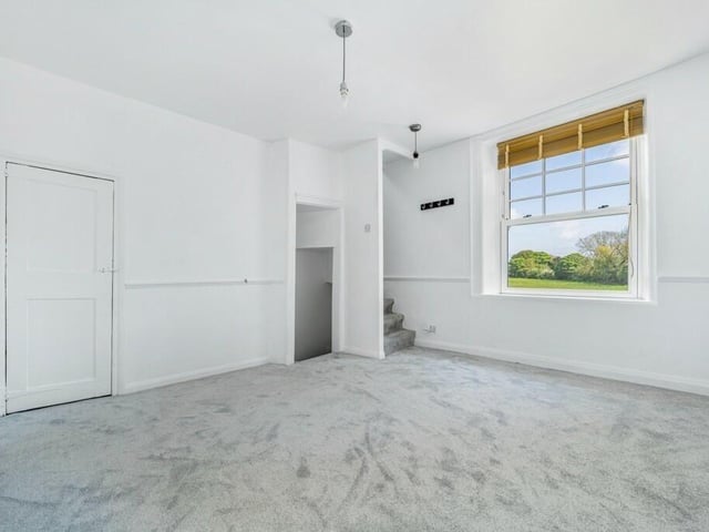 Another one of the first-floor bedrooms, with stairs leading down to the kitchen and up to the loft room.