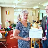 Dawn Willey, receiving a certificate of recognition, given 'in grateful appreciation of 50 years of dedicated services', with Martin Samuels, executive director for Adult Care and Community Wellbeing.