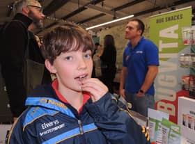 Joseph Hippisley tries out an edible salted locust on the Bugvita stall from Blankney at Lincolnshire Food and Gift fair.