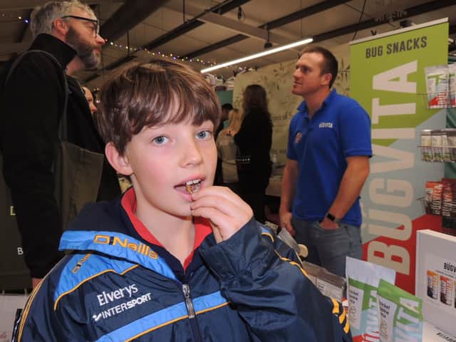 Joseph Hippisley tries out an edible salted locust on the Bugvita stall from Blankney at Lincolnshire Food and Gift fair.