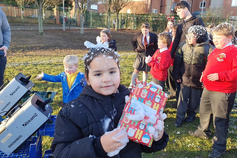 Almina Yusuf, six, had already collected her gift before getting 'snowed' on at Church Lane School.