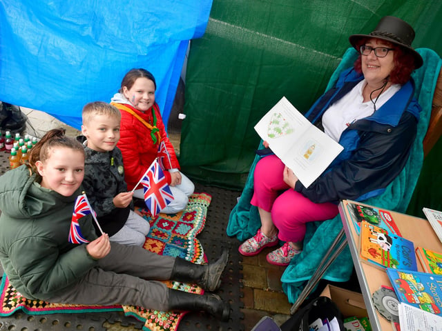 Party in the Market Place: Sue Morrison, of Boston Book Festival, reading to Pandora Dainty-Morrison 12, George Bradley, seven, and Lily-Star Dainty-Morrison, 13.