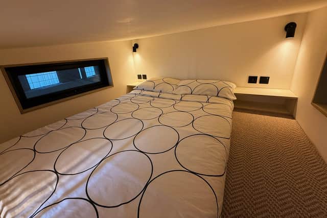 The cosy mezzanine-level bedroom in Vincent’s energy-efficient tiny home offers a modern, minimalist design and a warm, inviting atmosphere.